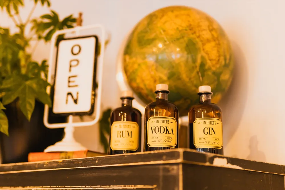 Vintage-Flaschen mit Rum, Vodka und Gin vor altem Globus an der Bar